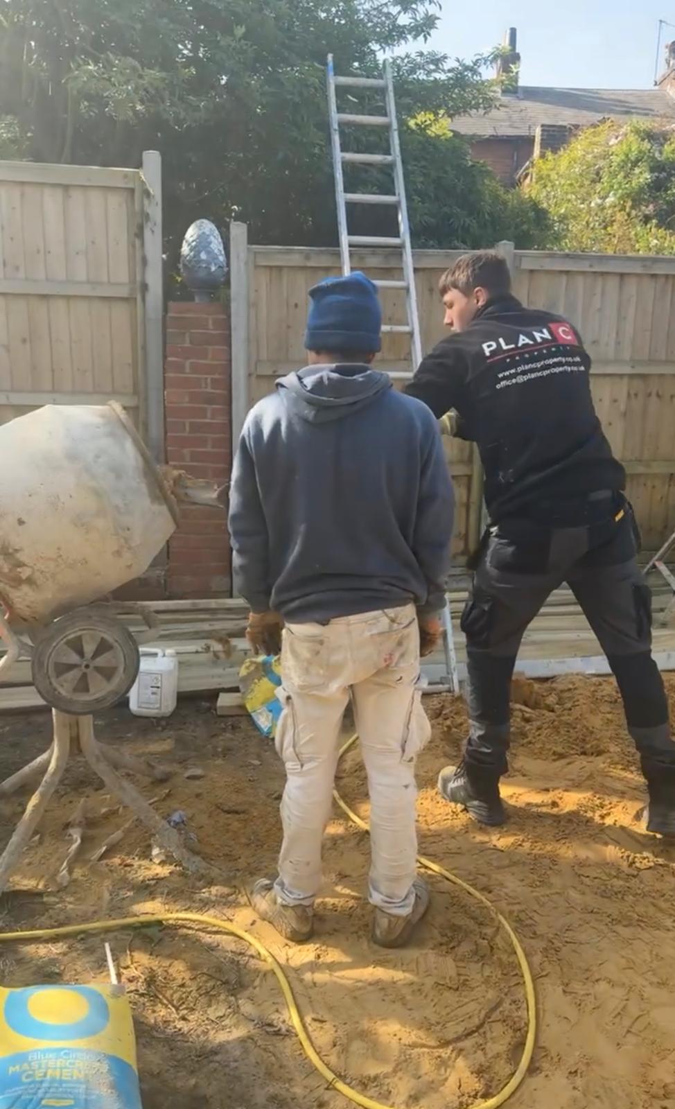 Team members working together with cement mixer on a construction project